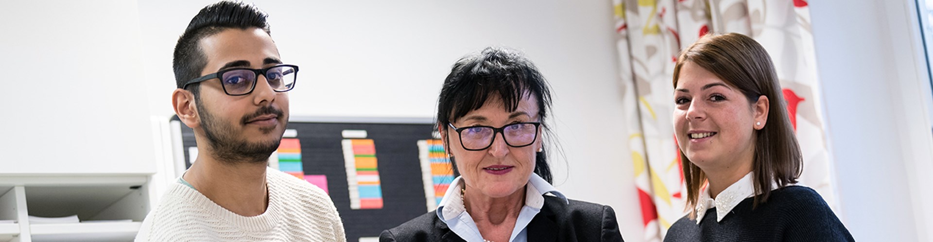 Drei Mitarbeiter am Arbeitsplatz